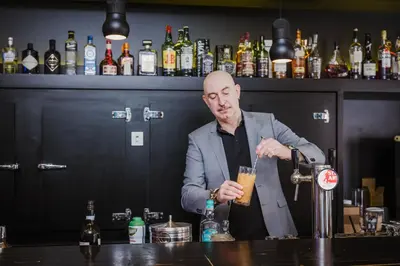 a man standing behind a bar making a drink at Corbie Mol in Mol