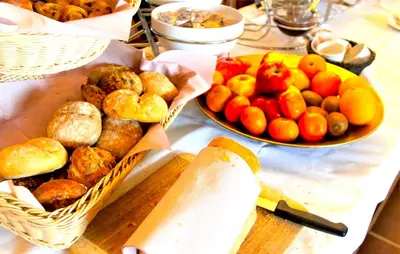 a table with two baskets of food and a bowl of fruit at Hotel Mille Colonnes in Leuven