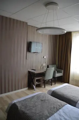 a hotel room with a desk and a bed at Hotel Mille Colonnes in Leuven