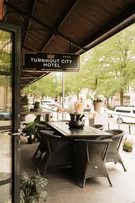 a table and chairs on a patio with a sign at Turnhout City Hotel in Turnhout