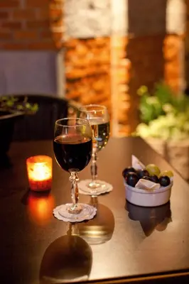 two glasses of wine on a table with a candle at Turnhout City Hotel in Turnhout