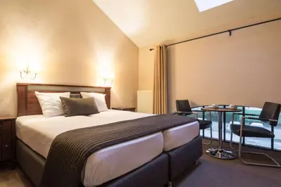 a hotel room with a bed and a table at Turnhout City Hotel in Turnhout