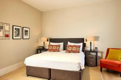 a bedroom with a large bed and a red chair at Hotel FRANQ in Antwerp