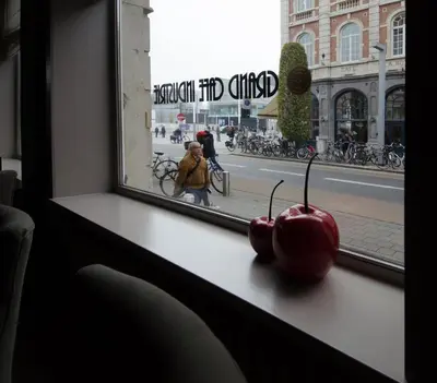two apples sitting on a window sill looking out at a street at Hotel Industrie in Leuven