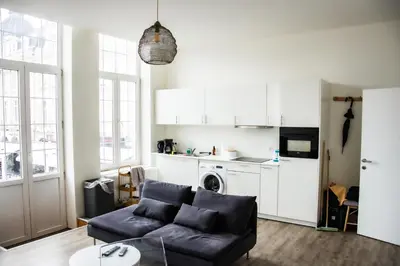 a living room with a couch and a kitchen at Hotel Industrie in Leuven
