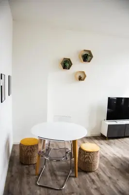 a white table and two stools in a room at Hotel Industrie in Leuven