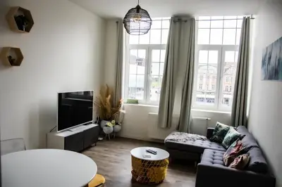 a living room with a couch and a tv at Hotel Industrie in Leuven