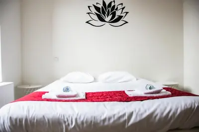 a bed with a red and white blanket on it at Hotel Industrie in Leuven