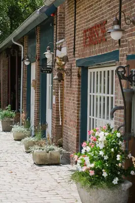 a brick building with potted plants in front of a door at B&B Hullebrug in Heist-op-den-Berg