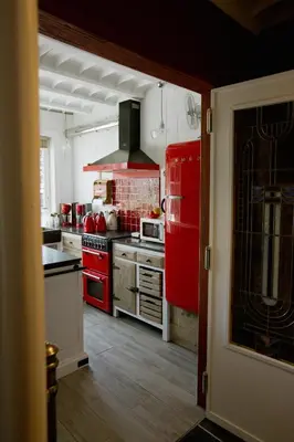 a kitchen with red appliances and a red refrigerator at B&B Hullebrug in Heist-op-den-Berg
