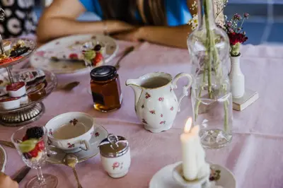 a table with a pink table cloth with a candle and tea cups at B&B Hullebrug in Heist-op-den-Berg