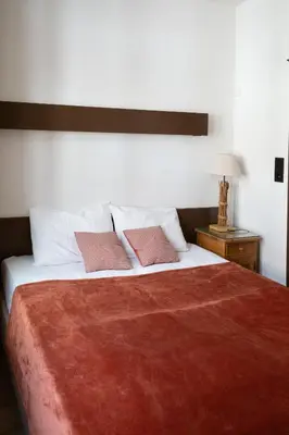 a bedroom with a large bed with two pink pillows at Hotel La Vieille Lanterne in Brussels