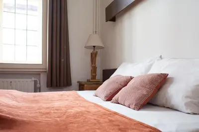 a bedroom with a bed with two pillows on it at Hotel La Vieille Lanterne in Brussels