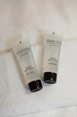 two tubes of sunscreen sitting on a white towel at Hotel La Vieille Lanterne in Brussels