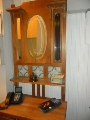a wooden cabinet with a mirror and a phone on a table at Hotel La Vieille Lanterne in Brussels