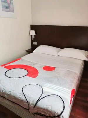a large bed with red flowers on it at Hotel Queen Mary in Brussels