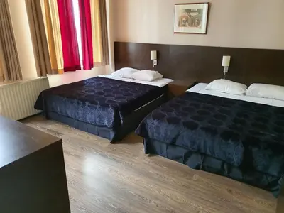 a hotel room with two beds in a room at Hotel Queen Mary in Brussels