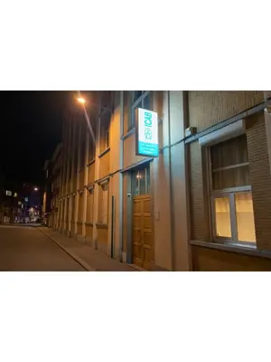 a sign on the side of a building at night at Institute Of Cultural Affairs in Brussels