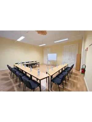 a large room with tables and chairs and a whiteboard at Institute Of Cultural Affairs in Brussels