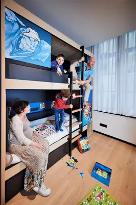 a woman and two children in a bunk bed at YOOMA Urban Lodge in Brussels