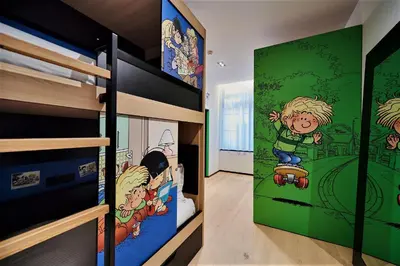a bedroom with bunk beds with cartoon characters on the walls at YOOMA Urban Lodge in Brussels