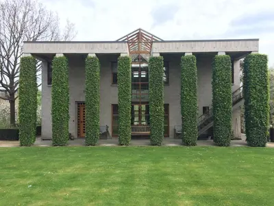 a building with ivy on the side of it at Le Jardin Des Sources in La Hulpe