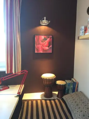 a corner of a bedroom with a bed and a lamp at Le Jardin Des Sources in La Hulpe