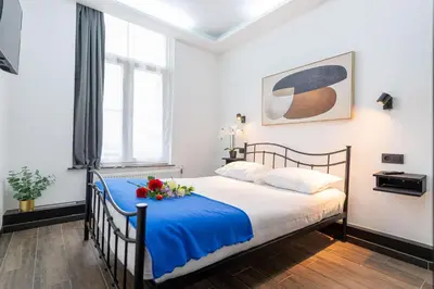 a bedroom with a bed with flowers on it at Hotel Le Grand Colombier in Brussels
