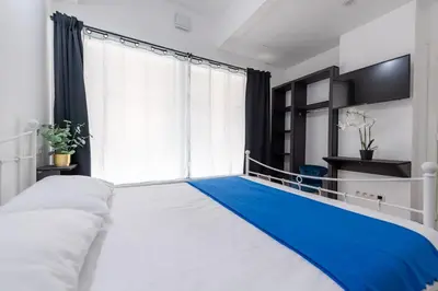 a bedroom with a large white bed and a window at Hotel Le Grand Colombier in Brussels