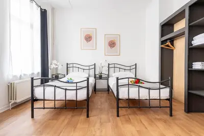 a room with two beds and two chairs at Hotel Abberdeen in Brussels