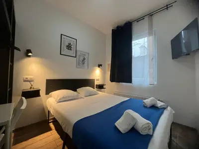 a bedroom with a large bed with two towels on it at Hotel Abberdeen in Brussels