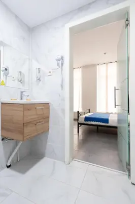 a bathroom with a sink and a bed in a room at Hotel Abberdeen in Brussels