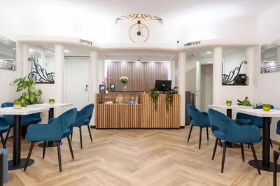 a room with tables and chairs and a clock on the wall at Hotel Abberdeen in Brussels