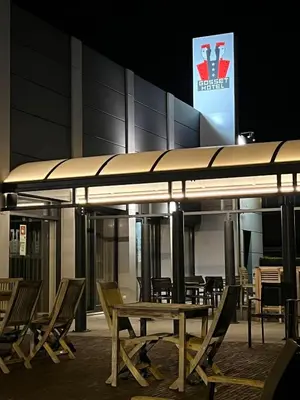 a group of tables and chairs in front of a building at Gosset Hotel in Groot-Bijgaarden