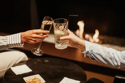 two people holding up glasses of wine on a table at Serwir Hotel in Sint-Niklaas