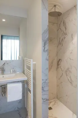 a white bathroom with a sink and a mirror at Serwir Hotel in Sint-Niklaas