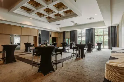 a large room with tables and chairs and windows at Serwir Hotel in Sint-Niklaas