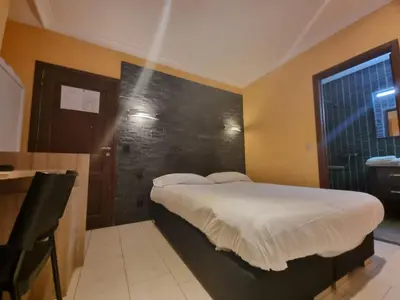 a bedroom with a bed with a black wall at Avalon Hotel in Overijse