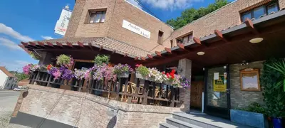 a brick building with flowers on a balcony at Avalon Hotel in Overijse
