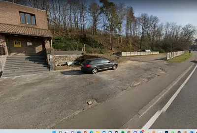 a car parked in a parking lot next to a house at Avalon Hotel in Overijse