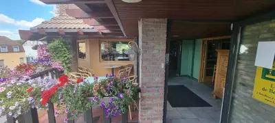 a patio with flowers on the side of a building at Avalon Hotel in Overijse