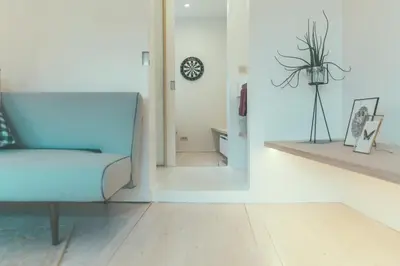 a living room with a blue couch and a mirror at AP8 city & park apartement in Aalst