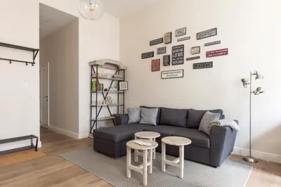 a living room with a couch and two tables at Cozy & Bright Apartment in Antwerp