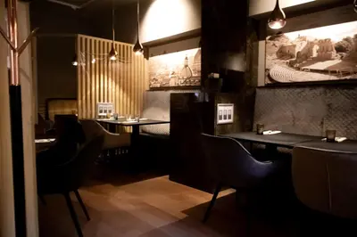 a restaurant with tables and chairs and a picture on the wall at Hotel Taormina Brussels Airport in Zaventem