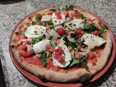 a pizza on a red plate on a table at Hotel Taormina Brussels Airport in Zaventem