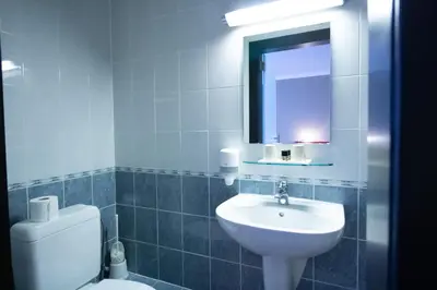 a bathroom with a sink and a toilet and a mirror at Hotel Taormina Brussels Airport in Zaventem