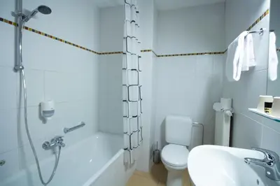 a bathroom with a shower and a toilet and a sink at Hotel Taormina Brussels Airport in Zaventem