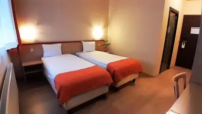 a hotel room with two beds in a room at Hotel Taormina Brussels Airport in Zaventem