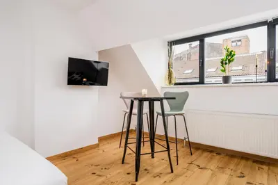 a small table in a living room with a window at Simone's Kitchen B&B in Antwerp