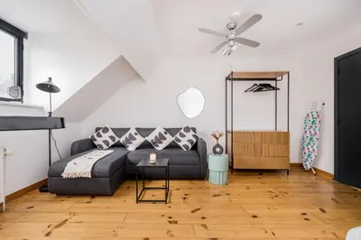 a living room with a couch and a ceiling fan at Simone's Kitchen B&B in Antwerp